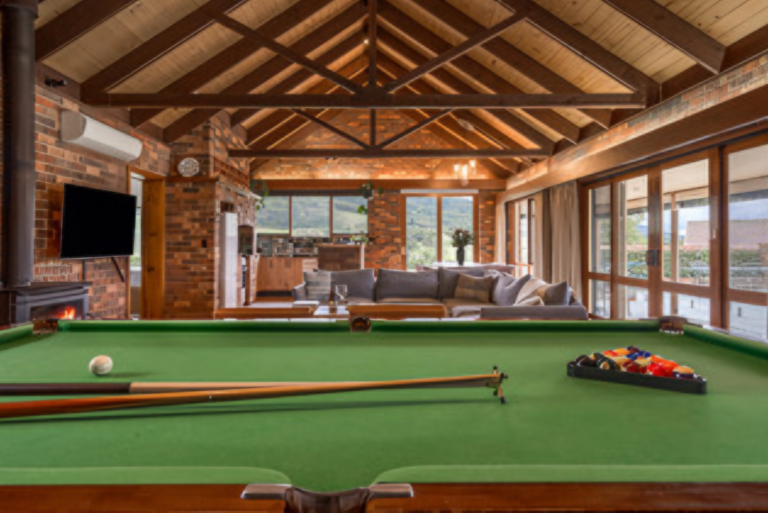 Rustic games room with cottage pool table, wood fireplace and vaulted timber ceilings at Langbrook Farm in the Yarra Valley.