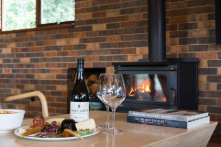 Local wine, cheese platter and wood fireplace inside luxury Langbrook Farm accommodation in the Yarra Valley